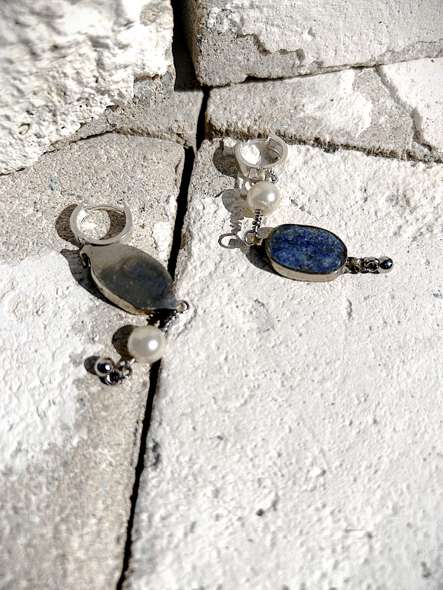 Paire de boucles d'oreilles composées d'une pâte de verre sertie en laiton, provenant d'un vieux collier d'Essaouira, de perles de culture issues d'un ancien collier de ma grand-mère, de deux anneaux en argent 925 à clipser à l'oreille (non soudés, conformément à la loi), de tiges en inox 316L torsadées et d'une pampille provenant d'un collier indien. Vue de face. Les éléments sont volontairement intervertis à chaque oreille, mais restent de même longueur.