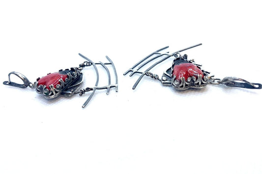 Boucles d'oreilles en argent, sur lequel est gravé l'idéogramme japonais du kokoro, qui est à la fois l'amour, l'ame, l'essence de tout. Par dessus sur une plateforme est serti un cœur en céramique raku. Sous cette partie haute de boucles d'oreilles est suspendue le symbole du Torii. Le tout est entièrement forgé en argent 950. Vue de profil.