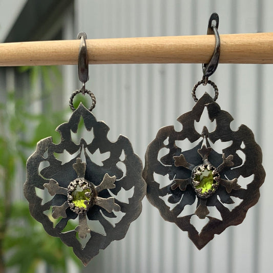 Ces boucles en argent sont constituées de deux plaques superposées et soudées avec un écart afin que la fleur centrale soit surélevée. Au creux de cette fleur repose un serti e vésuvianite d'un vert éclatant. Inspiré des motifs hatayi. vue de face. Crochets d'oreille à clips en argent.