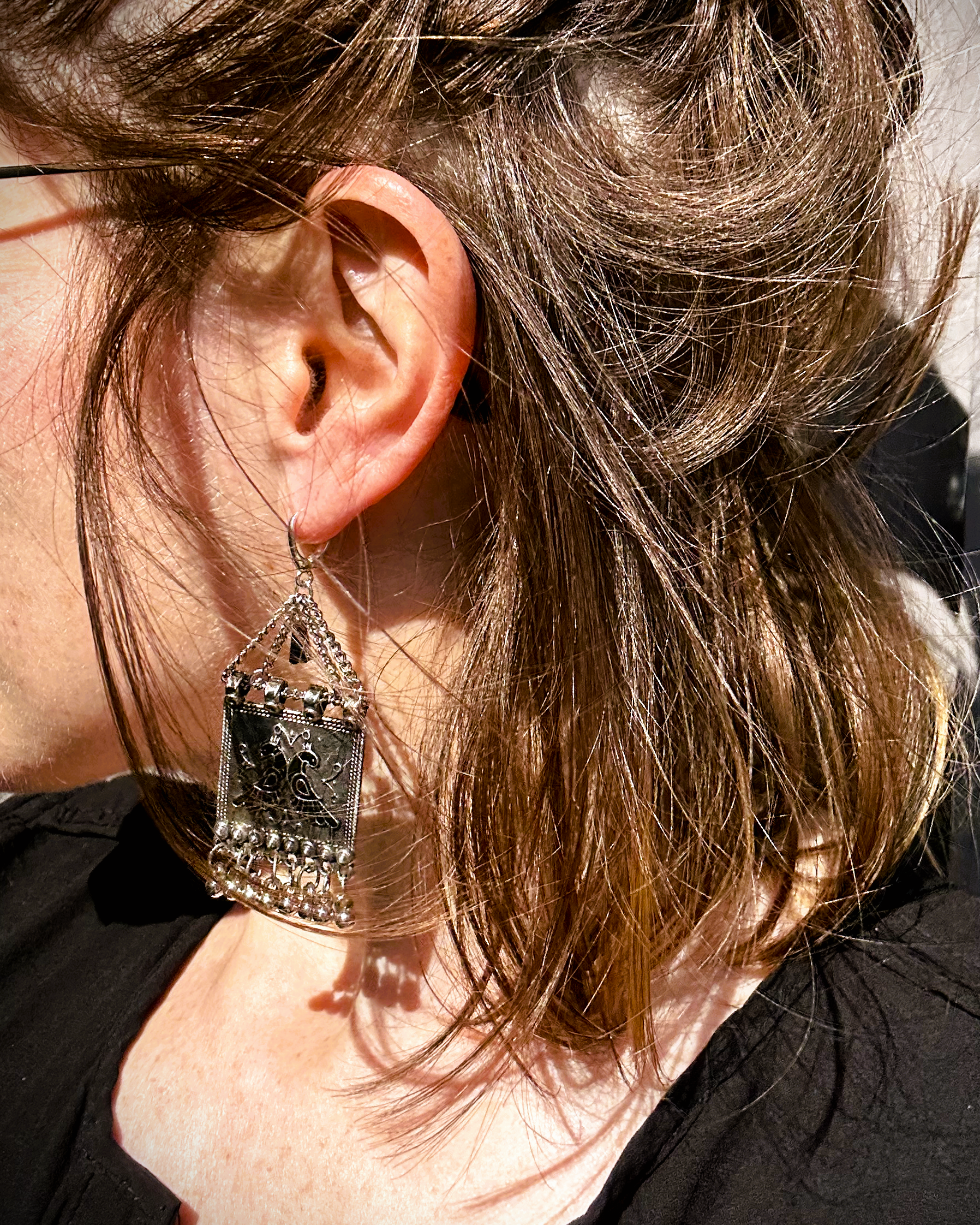 Boucles sur crochets sécurité en argent 950, composées d'un jeu de chainettes auxquelles  est suspendu une plaque de métal décoré de deux paons (cloisonné et pâte de verre). J'ai suspendu des pampilles récupéré sur un vieux collier indien.  jApreès avoir retiré la rouille, je les ai noirci à la peinture métal, puis brossé à la brosse acier. Elles sont protégé à la cire. Je voulais  créer d'inspiration indienne avec ce couple de paon aux couleurs chatoyantes vertes, bleues et rouges Vue portée au soleil.