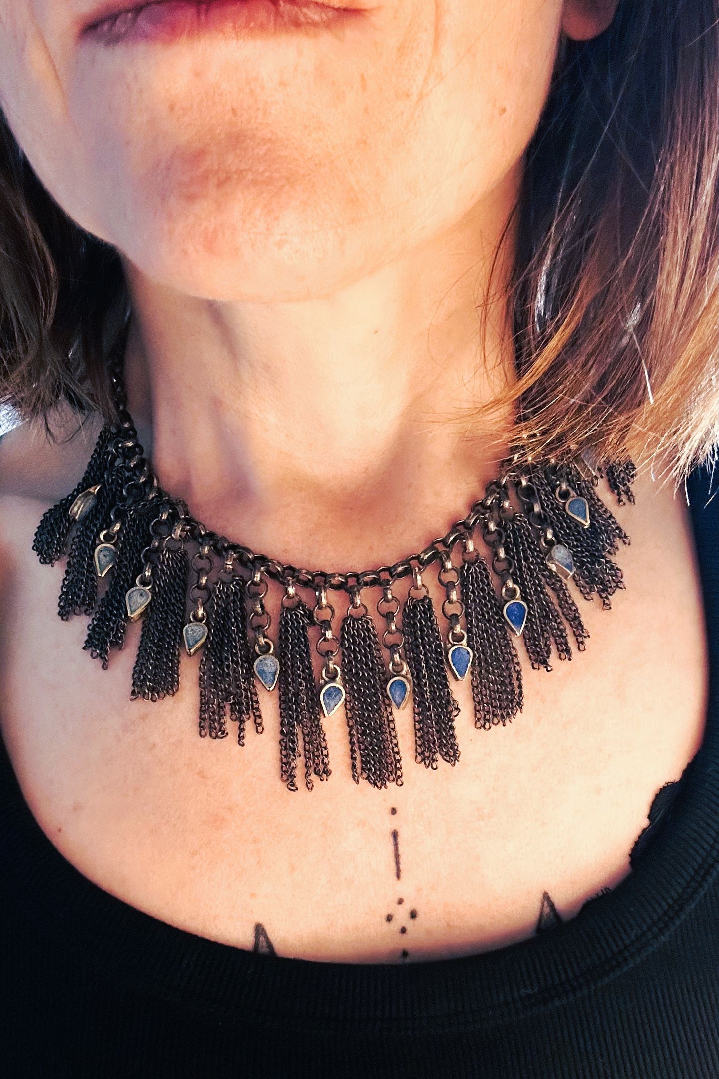 Collier en inox réalisé à de vieux maillons d'un collier cascade, de pampilles de chaines d'un collier de pampilles et de pendants en pate de verre bleu d'un vieux collier d'Essaouira. Vue porté
