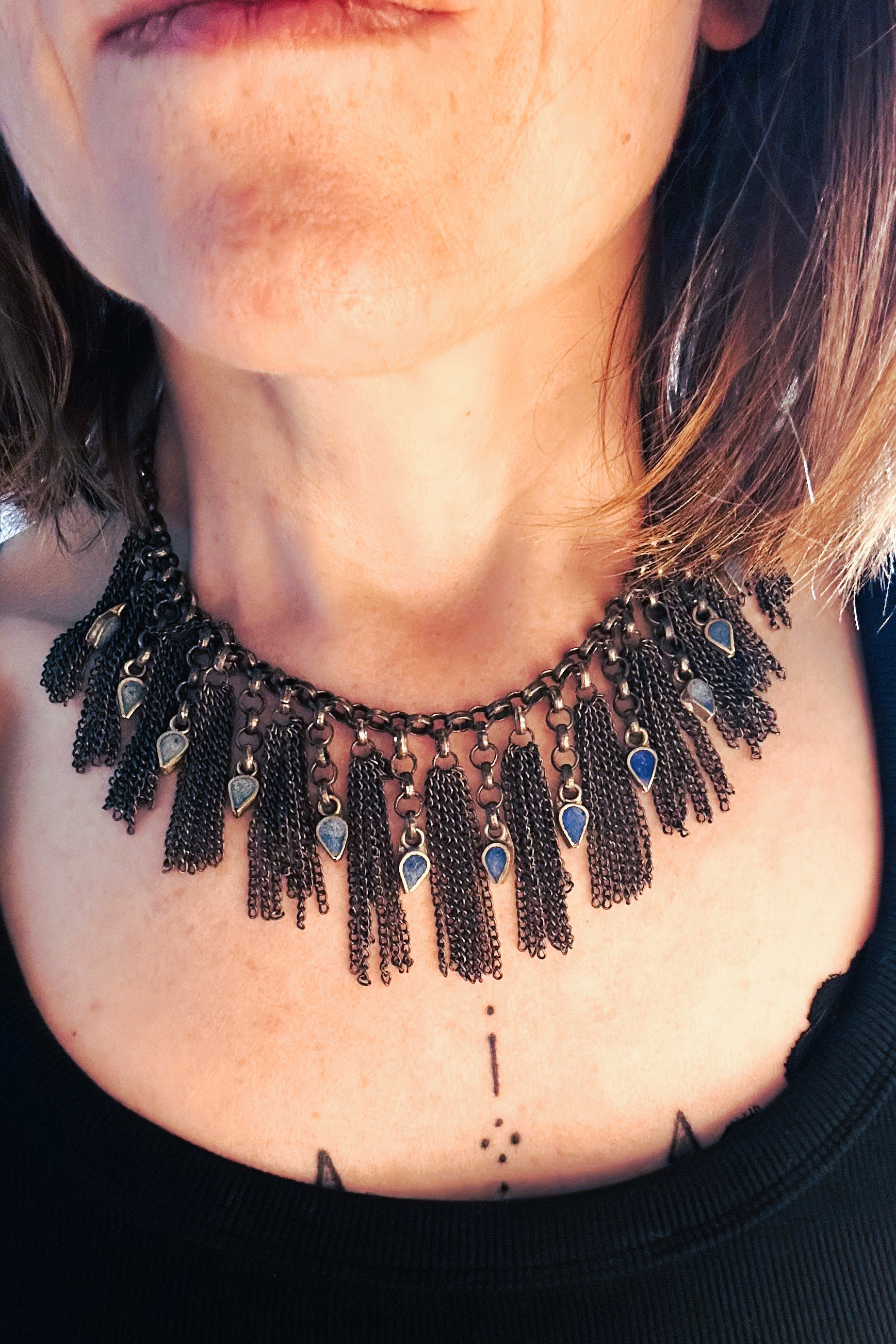 Collier en inox réalisé à de vieux maillons d'un collier cascade, de pampilles de chaines d'un collier de pampilles et de pendants en pate de verre bleu d'un vieux collier d'Essaouira. Vue porté