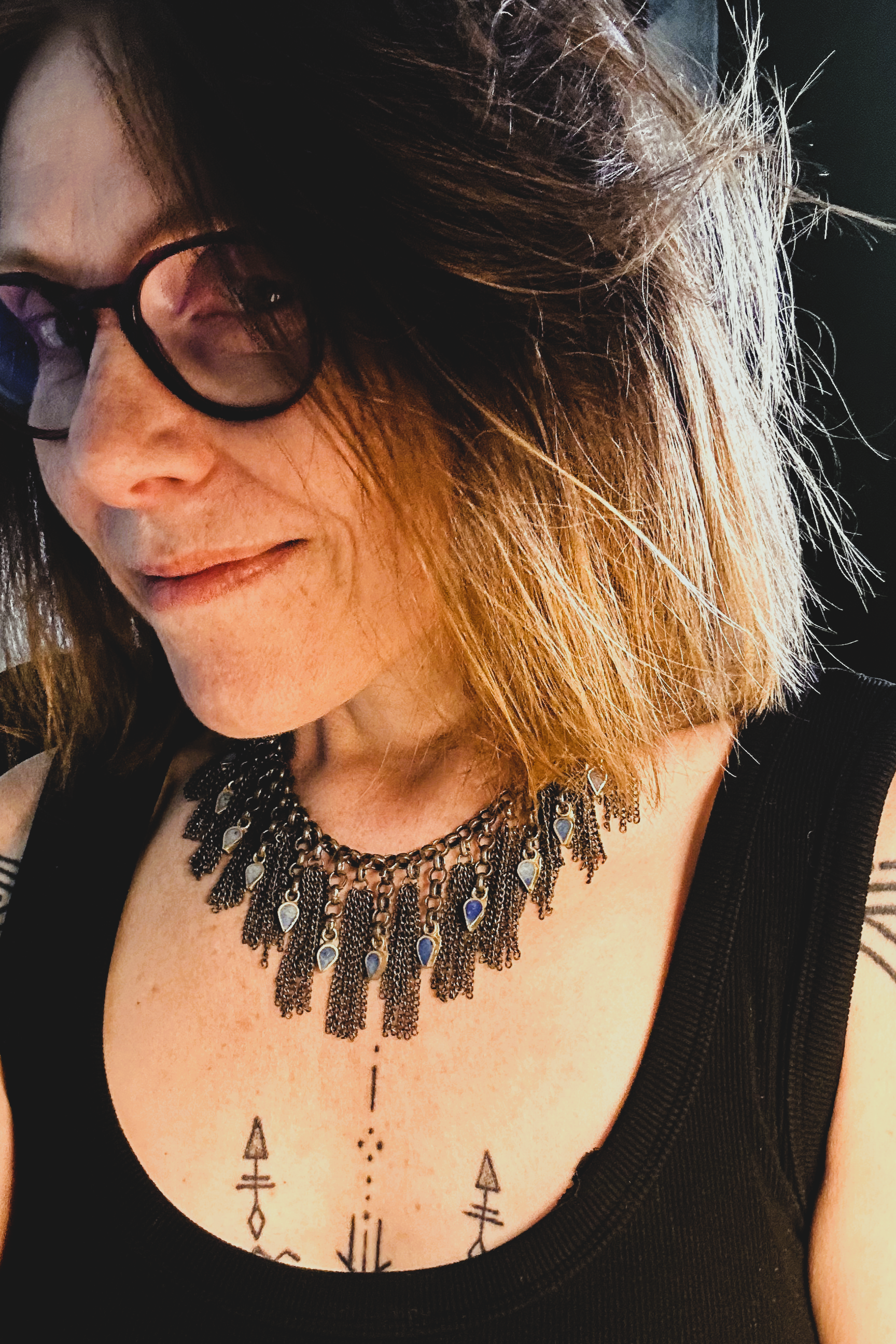 Collier en inox réalisé à de vieux maillons d'un collier cascade, de pampilles de chaines d'un collier de pampilles et de pendants en pate de verre bleu d'un vieux collier d'Essaouira.  Vue de profil porté.
