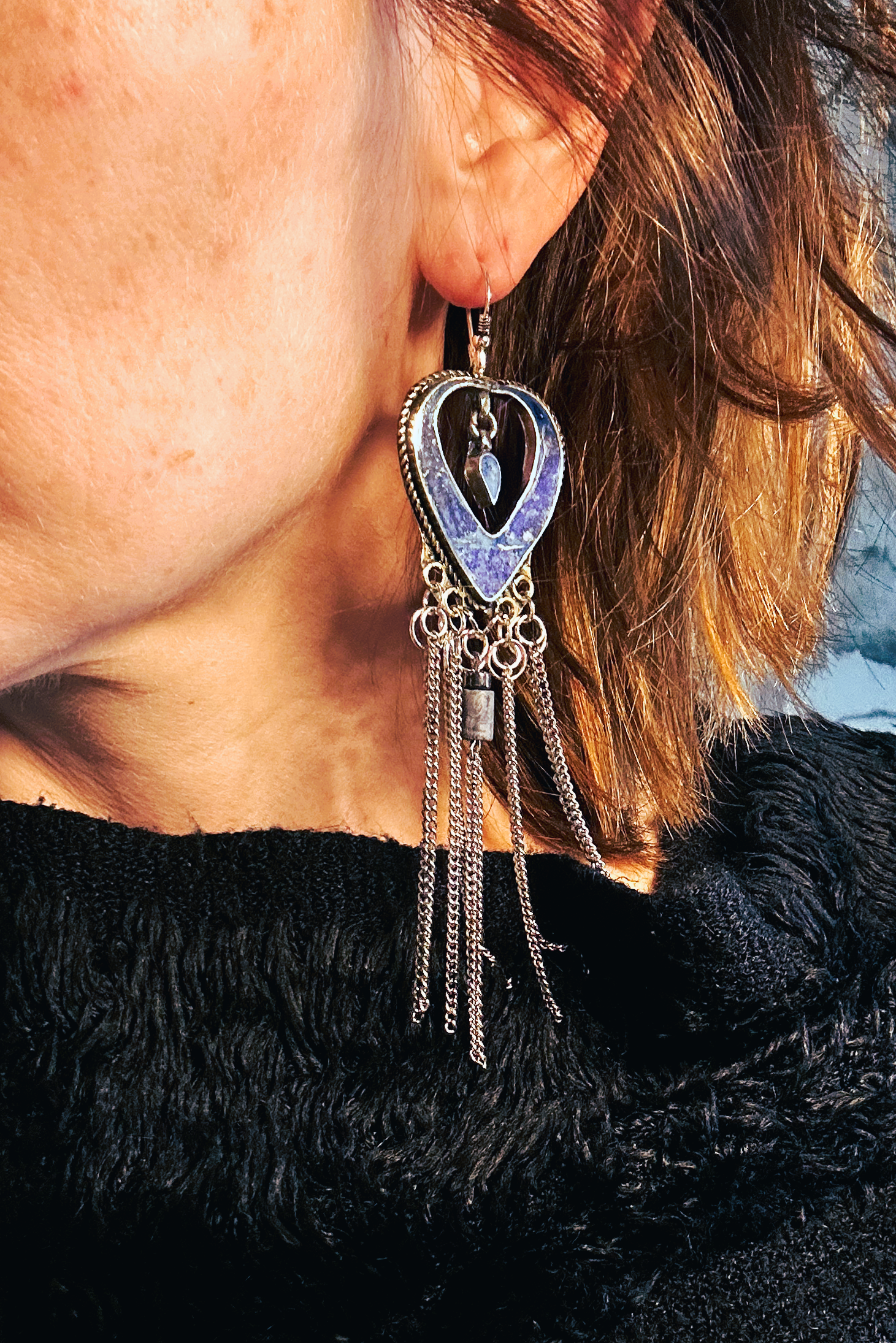 Boucles d'oreilles longues réalisées à partir de deux pendentif coeur d'un vieux collier d'Essaouira, sciées, limées, émerisé, polies et entièrement vernies, y comris la pate de verre bleu sertie dans le cloisonné. Dessous j'ai gardé qelques attaches pour construire un jeu d'anneau en inox auxquels j'ai supsendu des chaines et deux perles (une hématite, et une perle en pierre bleue). Au centre du coeur j'ai suspendu un petit charme du colllier pour illustrer les larmes du coeur. Vue portées.