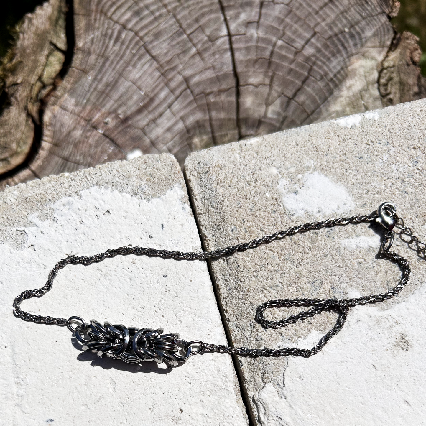 Ce collier ras-de-cou de 37 cm est composé d'une chaîne torsadée en acier inoxydable, récupérée sur un collier vintage avec médaillon central, au centre de laquelle j'ai intégré trois centimètres de maille byzantine.

J'ai soigneusement assemblé et structuré cette maille, appelée byzantine, à partir d'anneaux en acier inoxydable 304 (8 × 1,8 mm et 10 × 1,8 mm), préformés et sélectionnés pour leur solidité et leur finition biseautée.