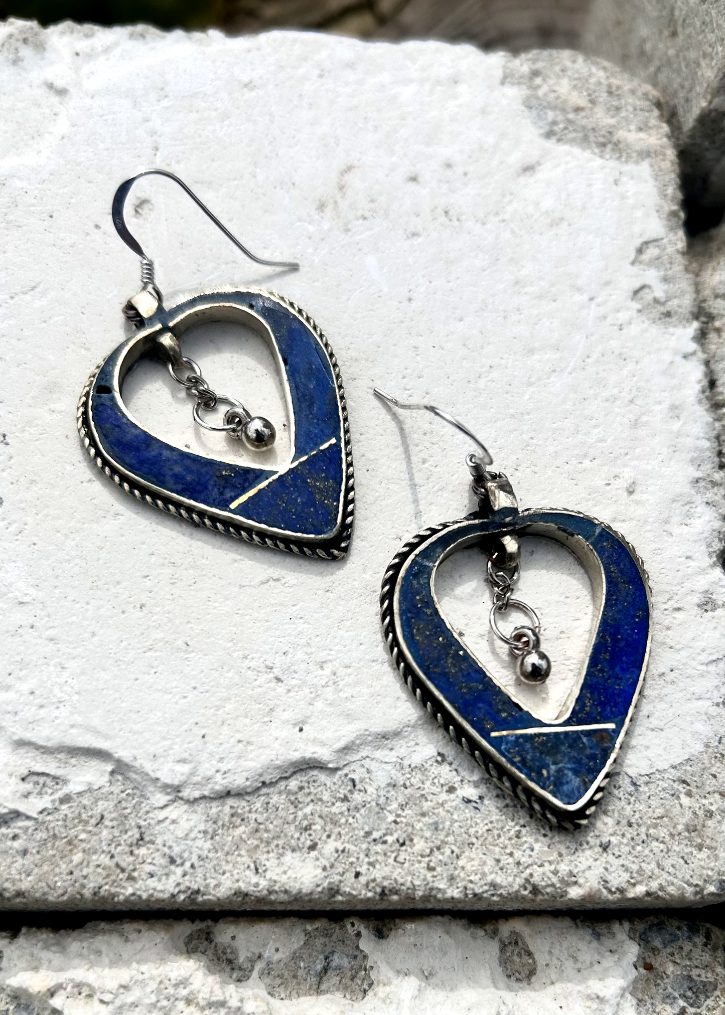 Boucles d'oreilles créée à parti de deux pendentifs d'un vieux collier d'Esaaouira; sciés, émerisés, polis, ils sont montées sur crochets simples en argent 950 (non soudés), au centre de ces coeurs (Hato en japonais), sont suspendus des petites pampilles indiennes. Vue de dessus.