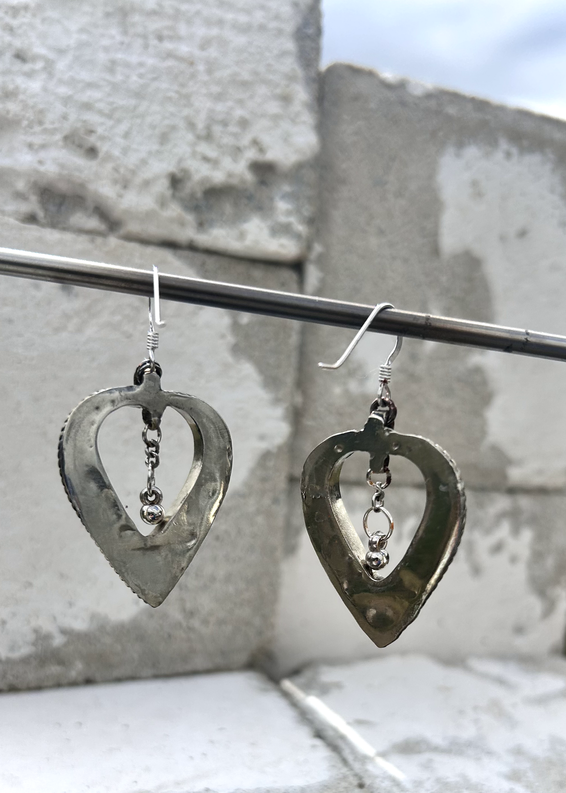 Boucles d'oreilles créée à parti de deux pendentifs d'un vieux collier d'Esaaouira; sciés, émerisés, polis, ils sont montées sur crochets simples en argent 950 (non soudés), au centre de ces coeurs (Hato en japonais), sont suspendus des petites pampilles indiennes. Vue du dos.