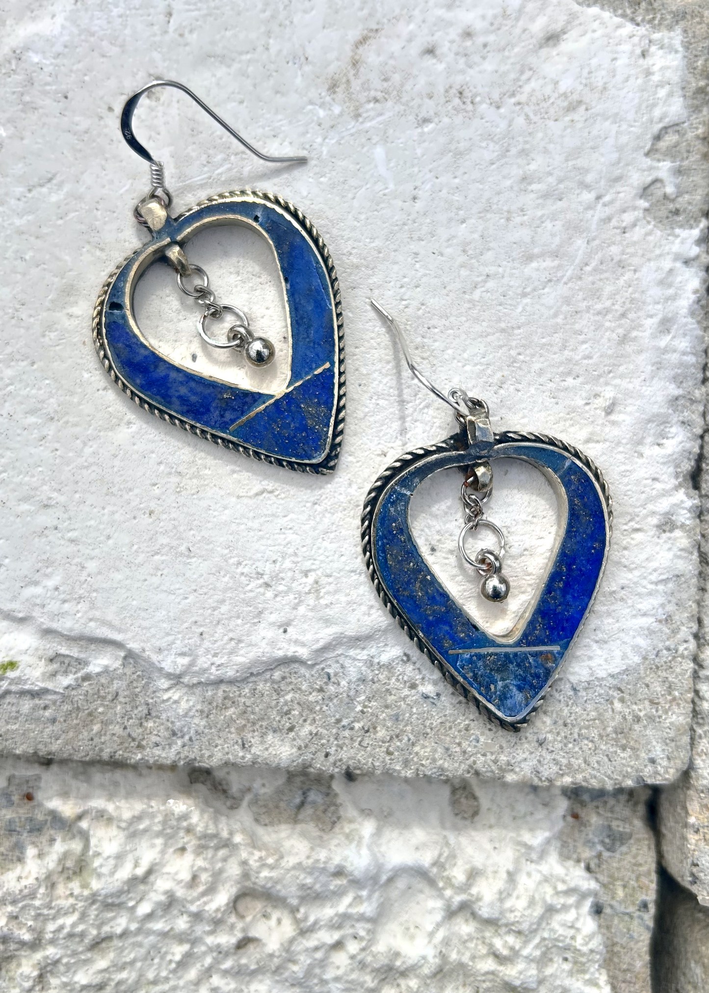 Boucles d'oreilles créée à parti de deux pendentifs d'un vieux collier d'Esaaouira; sciés, émerisés, polis, ils sont montées sur crochets simples en argent 950 (non soudés), au centre de ces coeurs (Hato en japonais), sont suspendus des petites pampilles indiennes. Vue de dessus