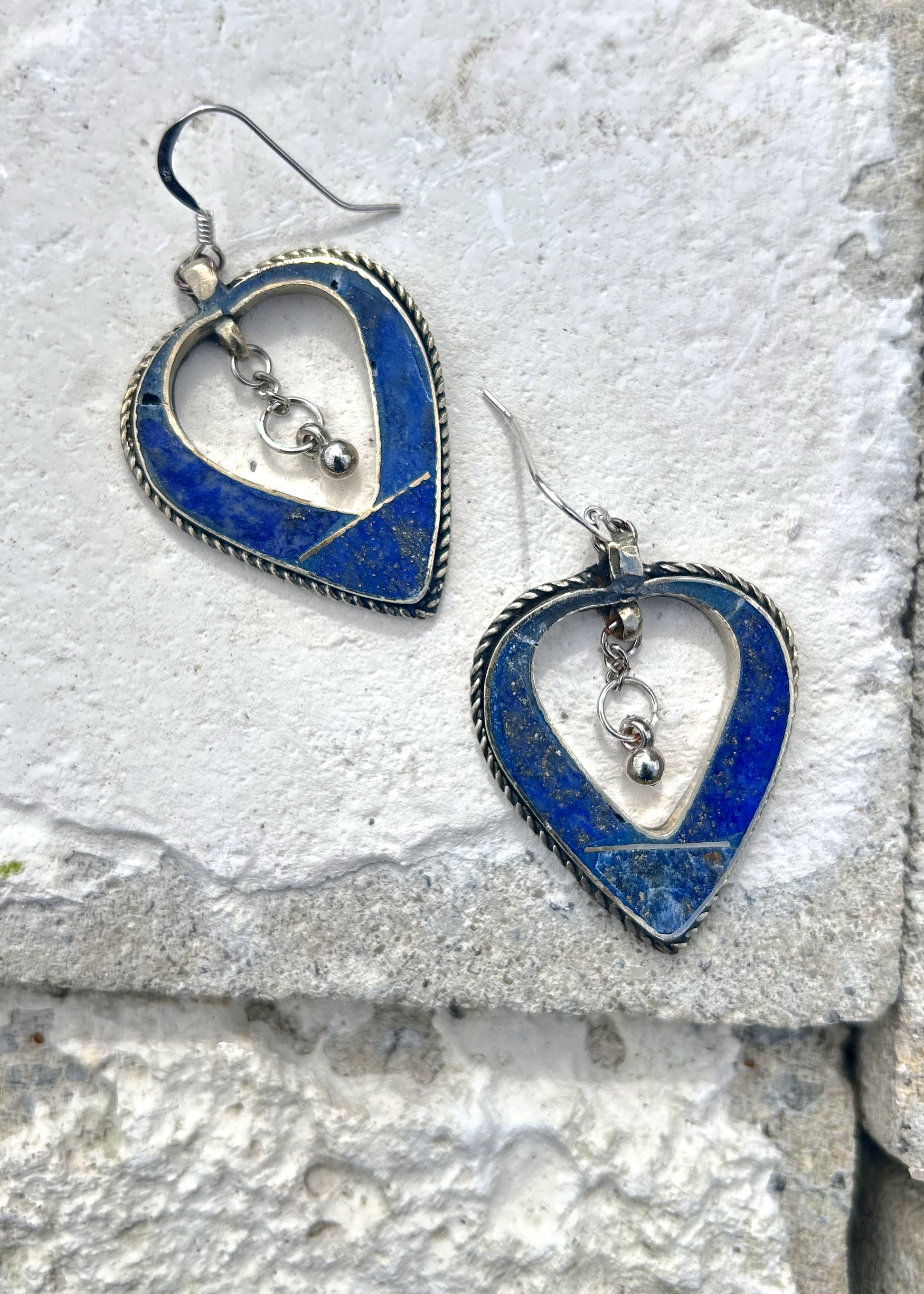 Boucles d'oreilles créée à parti de deux pendentifs d'un vieux collier d'Esaaouira; sciés, émerisés, polis, ils sont montées sur crochets simples en argent 950 (non soudés), au centre de ces coeurs (Hato en japonais), sont suspendus des petites pampilles indiennes. Vue de dessus