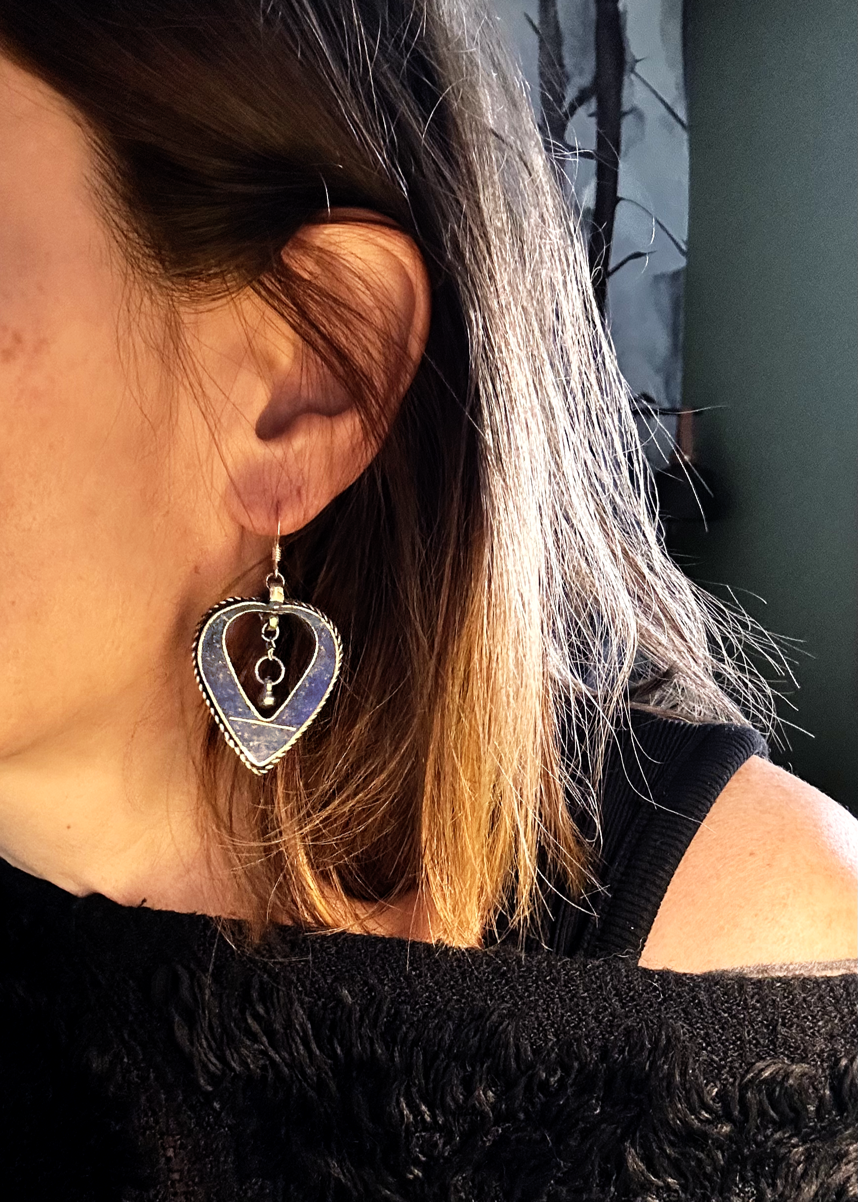 Boucles d'oreilles créée à parti de deux pendentifs d'un vieux collier d'Esaaouira; sciés, émerisés, polis, ils sont montées sur crochets simples en argent 950 (non soudés), au centre de ces coeurs (Hato en japonais), sont suspendus des petites pampilles indiennes. Vue portées de profil.