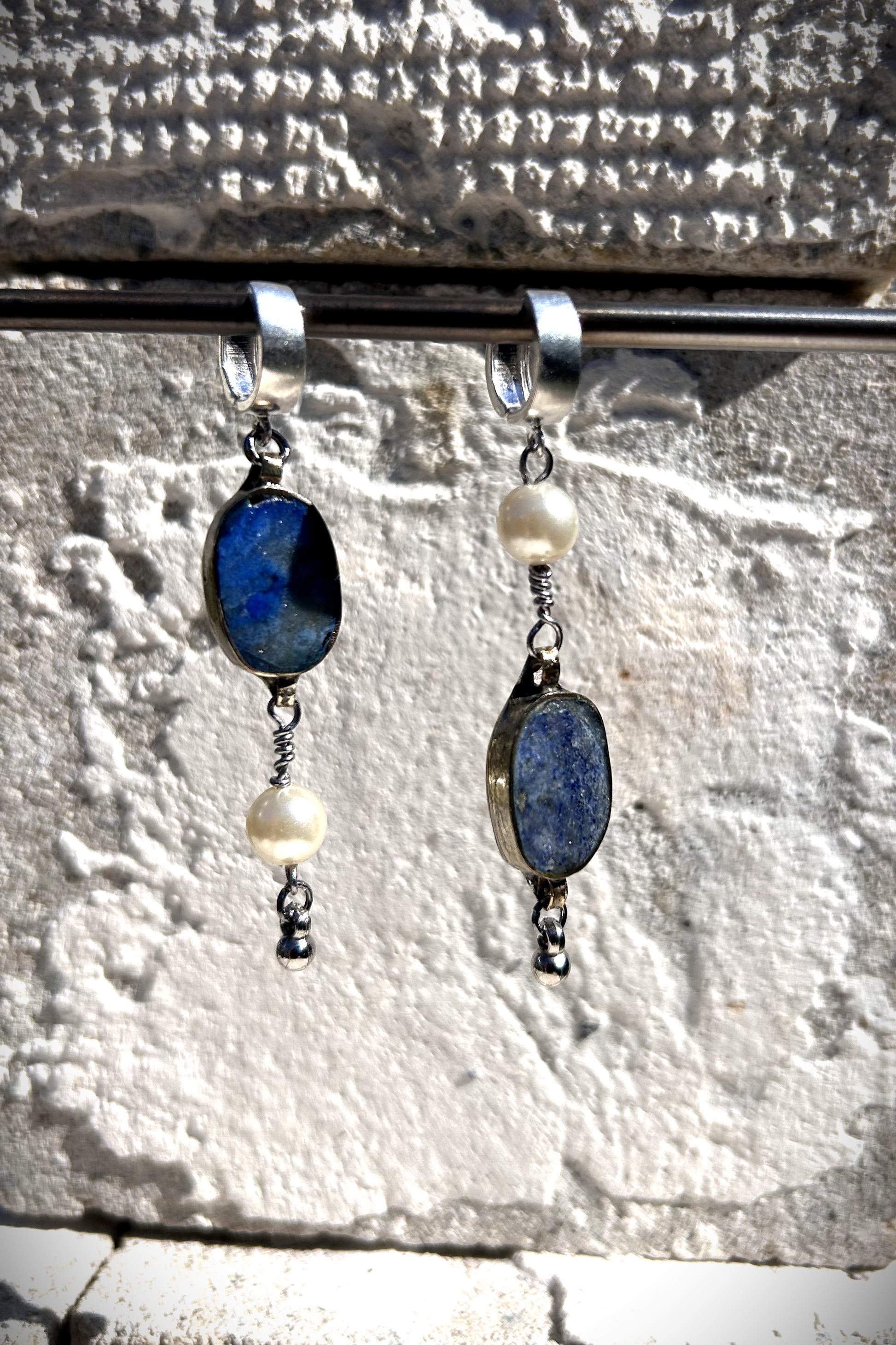 Paire de boucles d'oreilles composées d'une pâte de verre sertie en laiton, provenant d'un vieux collier d'Essaouira, de perles de culture issues d'un ancien collier de ma grand-mère, de deux anneaux en argent 925 à clipser à l'oreille (non soudés, conformément à la loi), de tiges en inox 316L torsadées et d'une pampille provenant d'un collier indien. Vue de face. Les éléments sont volontairement intervertis à chaque oreille, mais restent de même longueur.