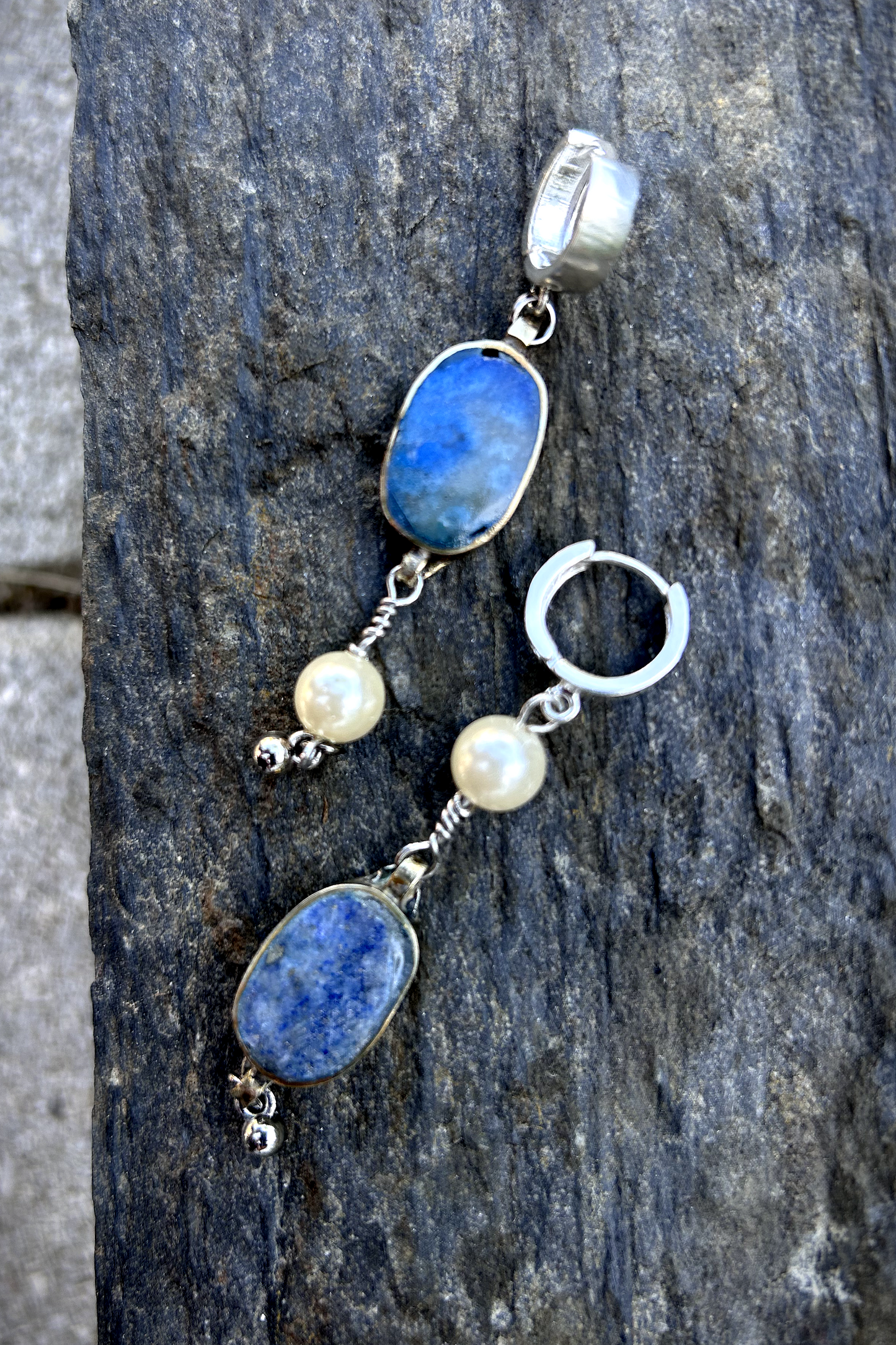 Paire de boucles d'oreilles composées d'une pâte de verre sertie en laiton, provenant d'un vieux collier d'Essaouira, de perles de culture issues d'un ancien collier de ma grand-mère, de deux anneaux en argent 925 à clipser à l'oreille (non soudés, conformément à la loi), de tiges en inox 316L torsadées et d'une pampille provenant d'un collier indien. Vue de face. Les éléments sont volontairement intervertis à chaque oreille, mais restent de même longueur.