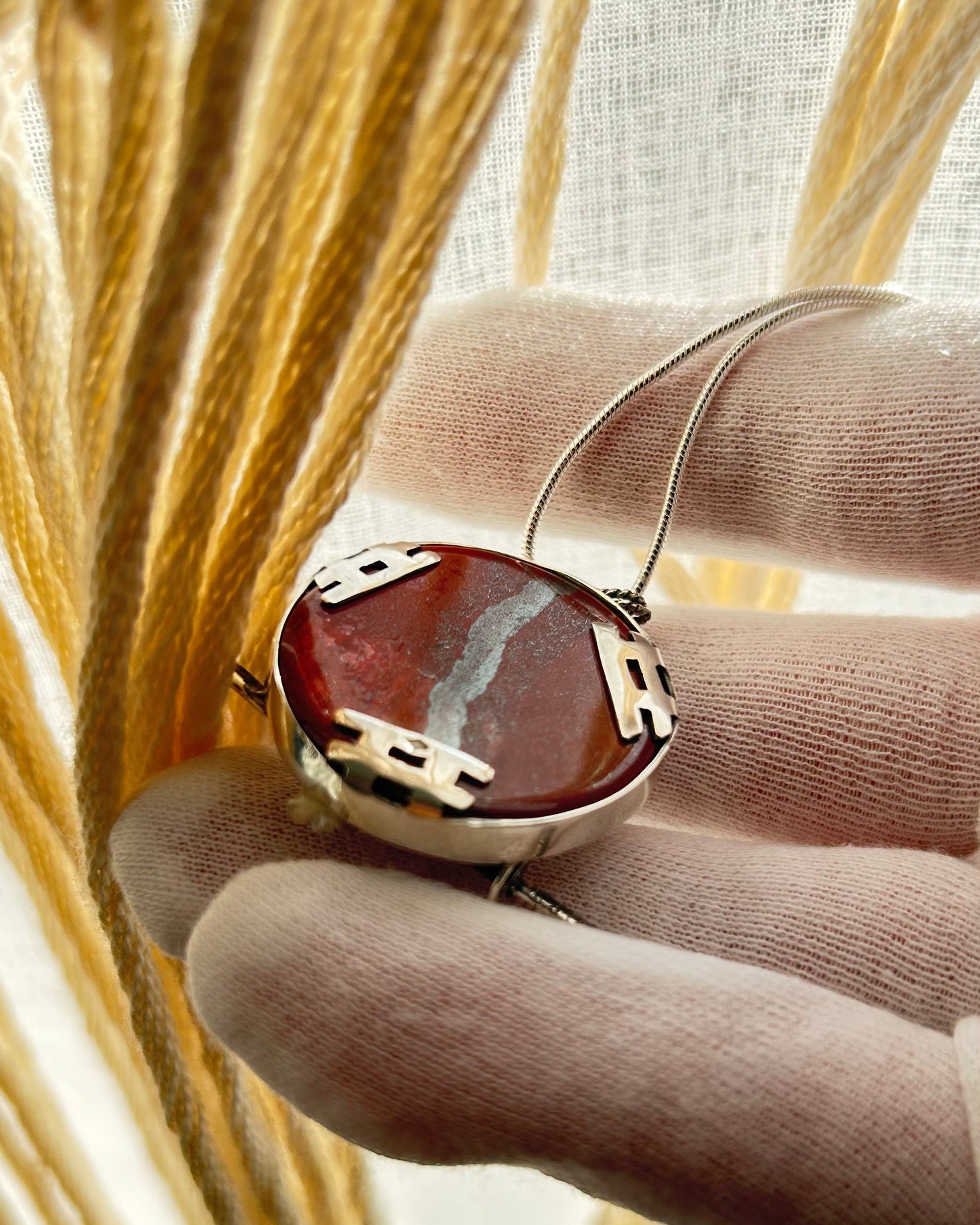 pendentif en argent vue de dos, sertissage par trois torii en argent rabattus sur la pierre. Poinçon.