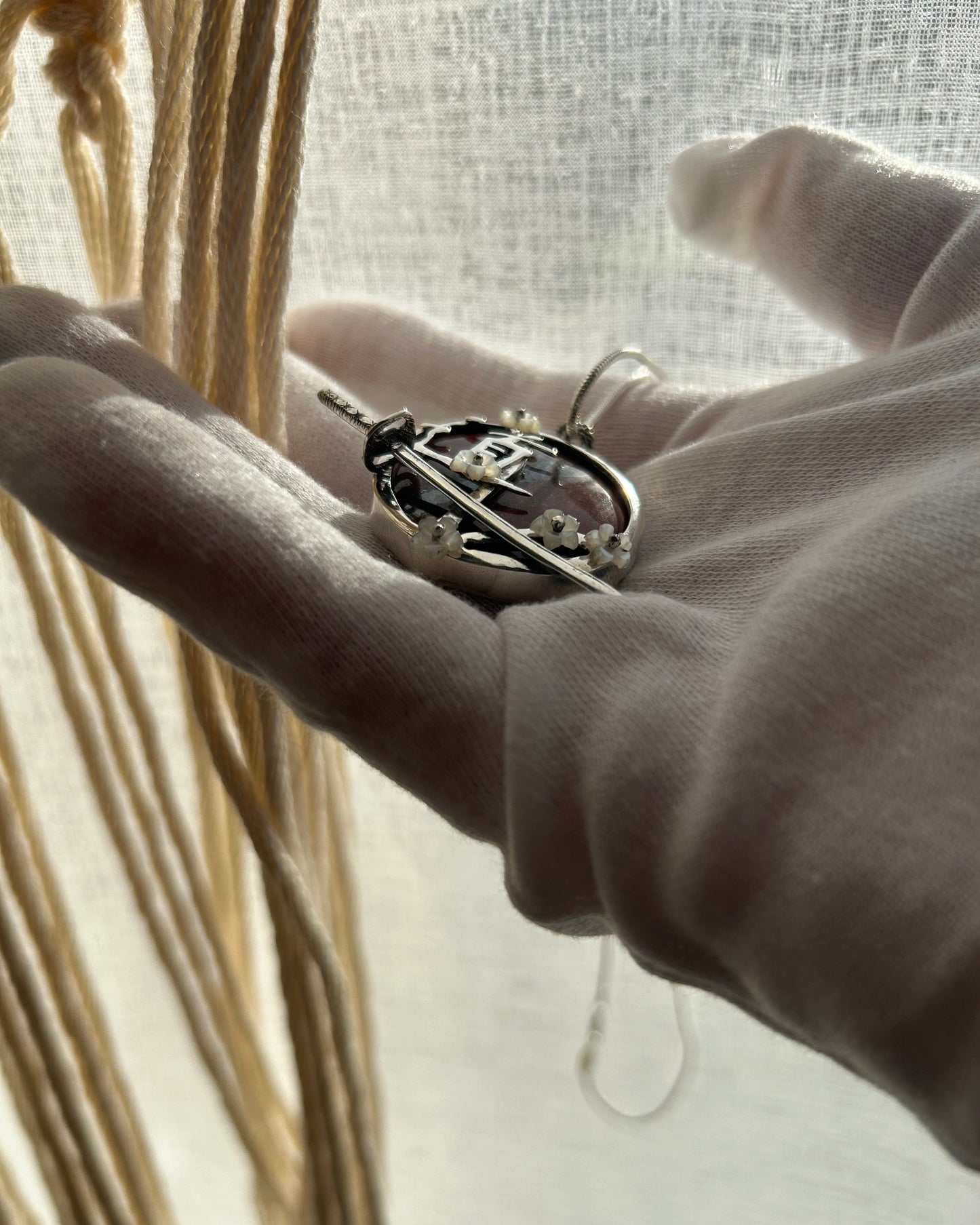 pendentif en argent avec sabre de l'iaido, fleurs de sakura en nacre, symbole du Do en japonais. Vue de profil. Collier maille serpent.