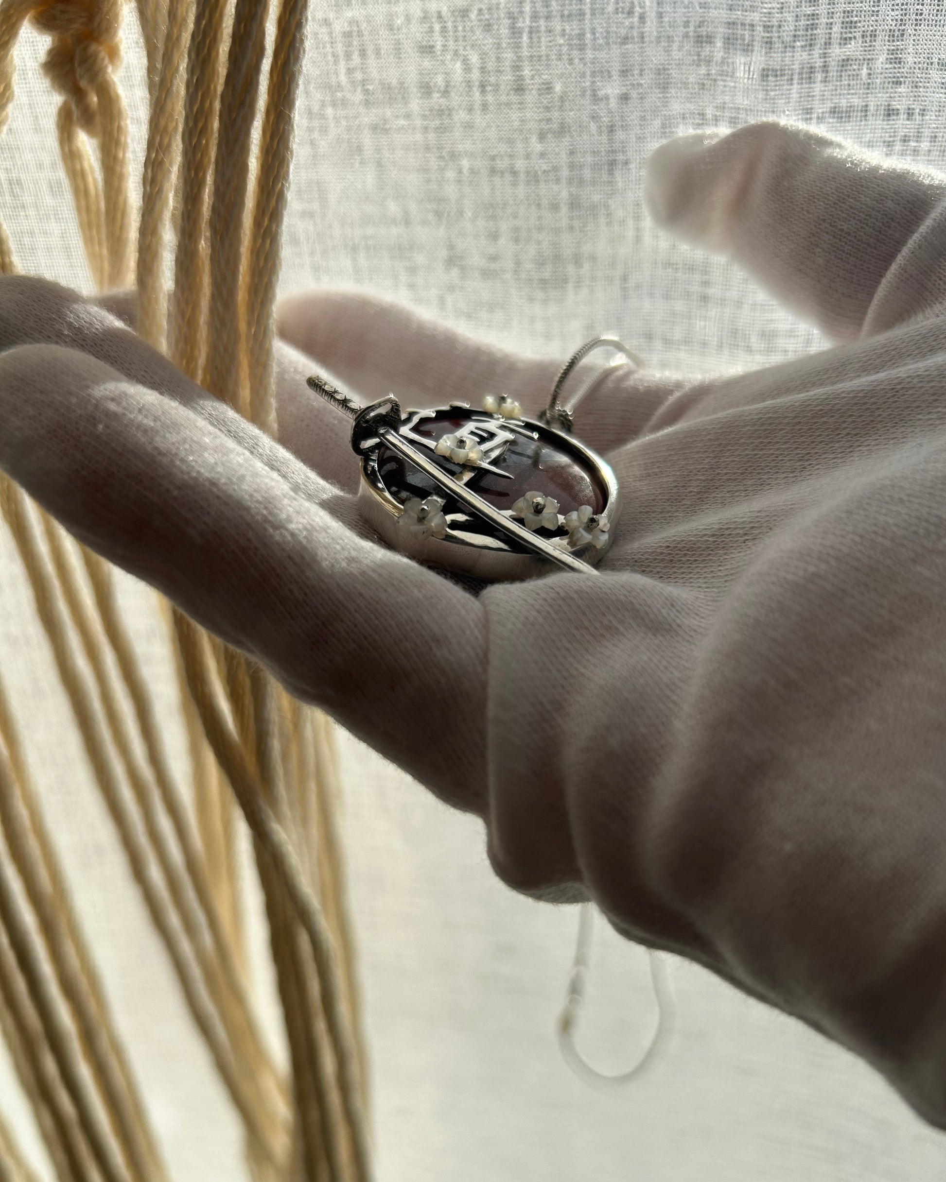 pendentif en argent avec sabre de l'iaido, fleurs de sakura en nacre, symbole du Do en japonais. Vue de profil. Collier maille serpent.