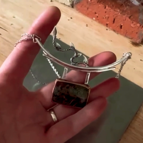 Collier en argent, inspiré par le dragon japonais et le torii. Chaîne en maille corde de 46 cm, répartie de part et d'autre de l'arche réalisée en fil de 2 mm, où est suspendu un serti composé d'un tour en cuivre et d'un dos en argent avec un dragon ajouré. Sur le fil, une queue de dragon en fil d'argent a été soudée. Vidéo du collier porté.