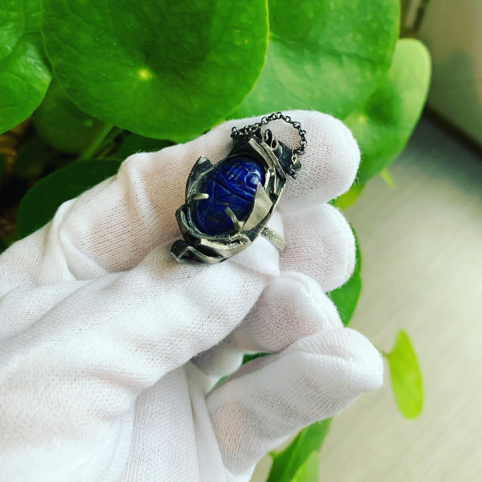 Bague en argent forgée à partir de débris modelés et agencés sans transformation, formant une carapace autour d'un lapis-lazuli sculpté en scarabée. Vue de dessus